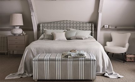 Camera da letto con testiera e cassapanca rivestite nei tessuti a righe della collezione Orton di Romo. In vendita c’è soltanto il tessuto al metro: arredi e complementi della scena non sono compresi.